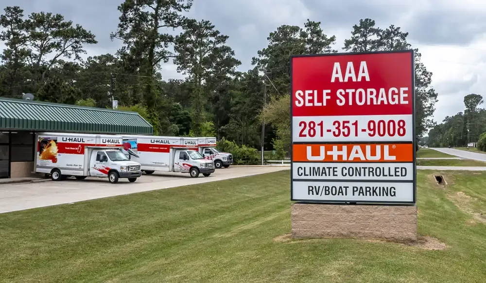 AAA Self Storage signage by the main road and U-Hauls in parking lot.