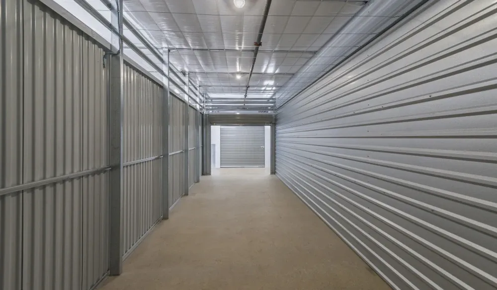 Interior view of a large, indoor storage unit with doors at both ends at Bergstrom Storage.