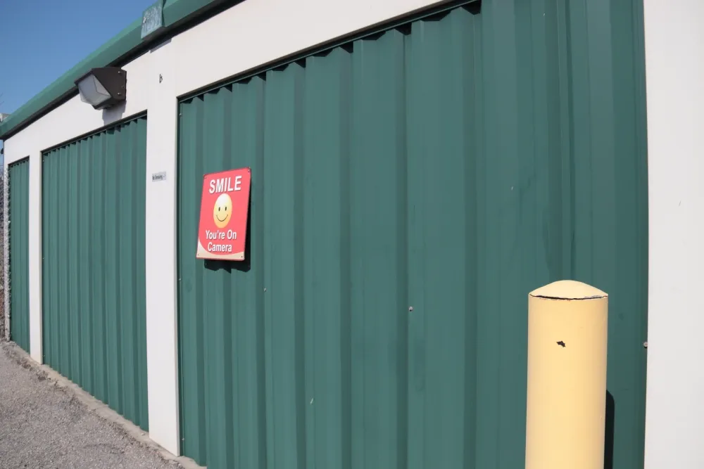 View of "smile you're on camera"" sign at Columbia Self Storage facility.