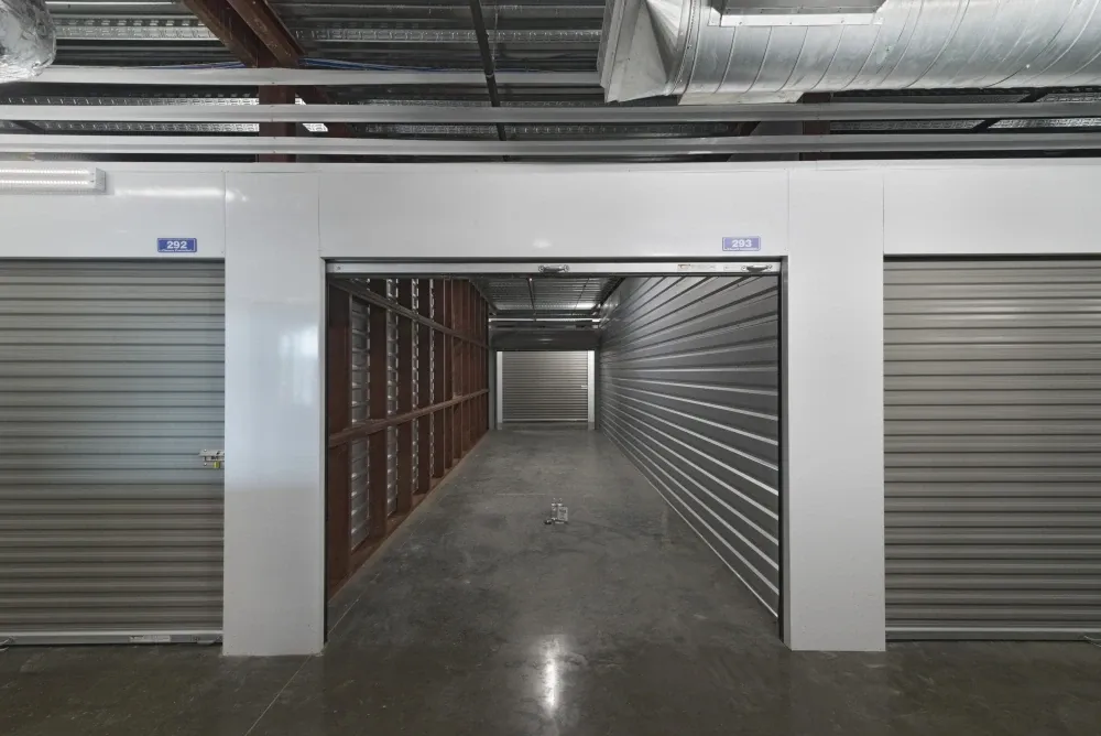 Interior view of a self-storage unit with an open roll-up door at EaDo Storage facility.