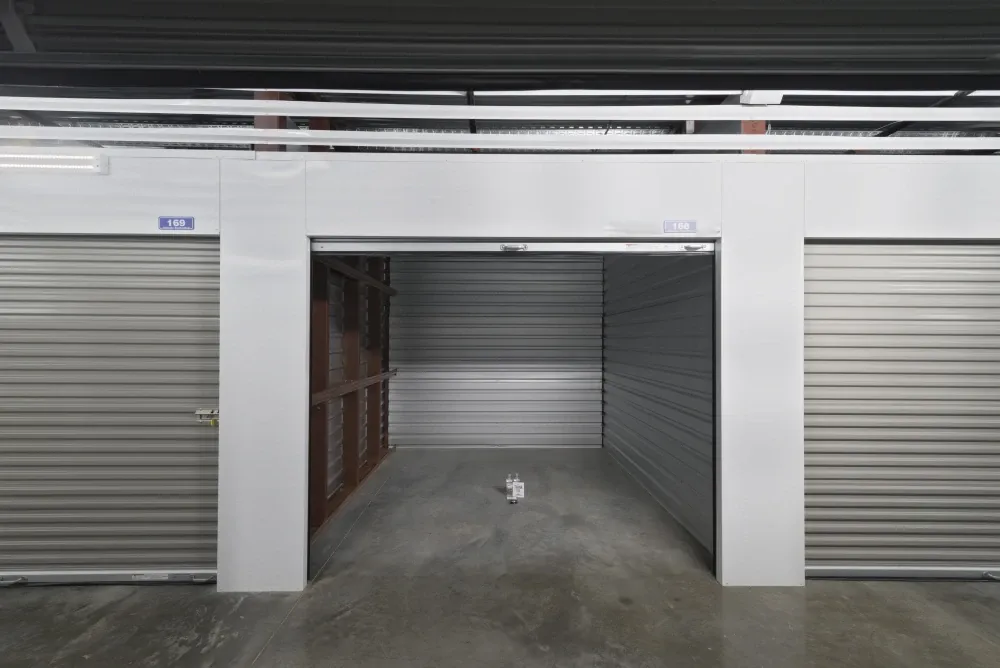 Interior view of a self-storage unit with an open roll-up door at EaDo Storage facility.