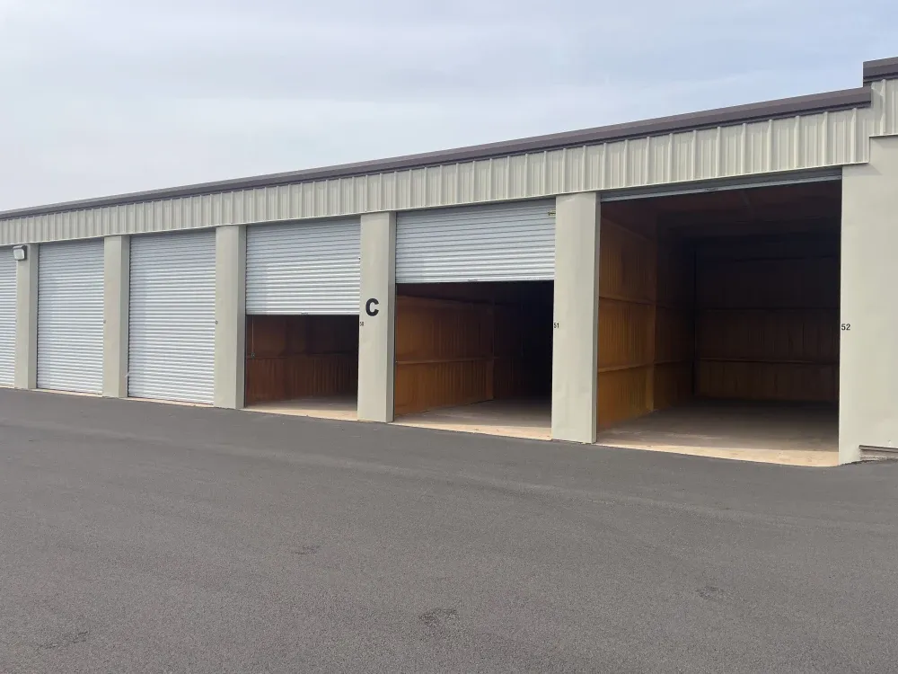 Open roll-up doors revealing storage units at San Angelo Boat Storage.