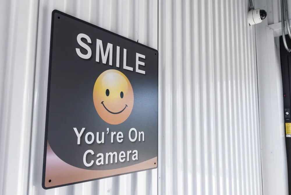 "Smile you're on camera" sign at Valley Ranch Storage.